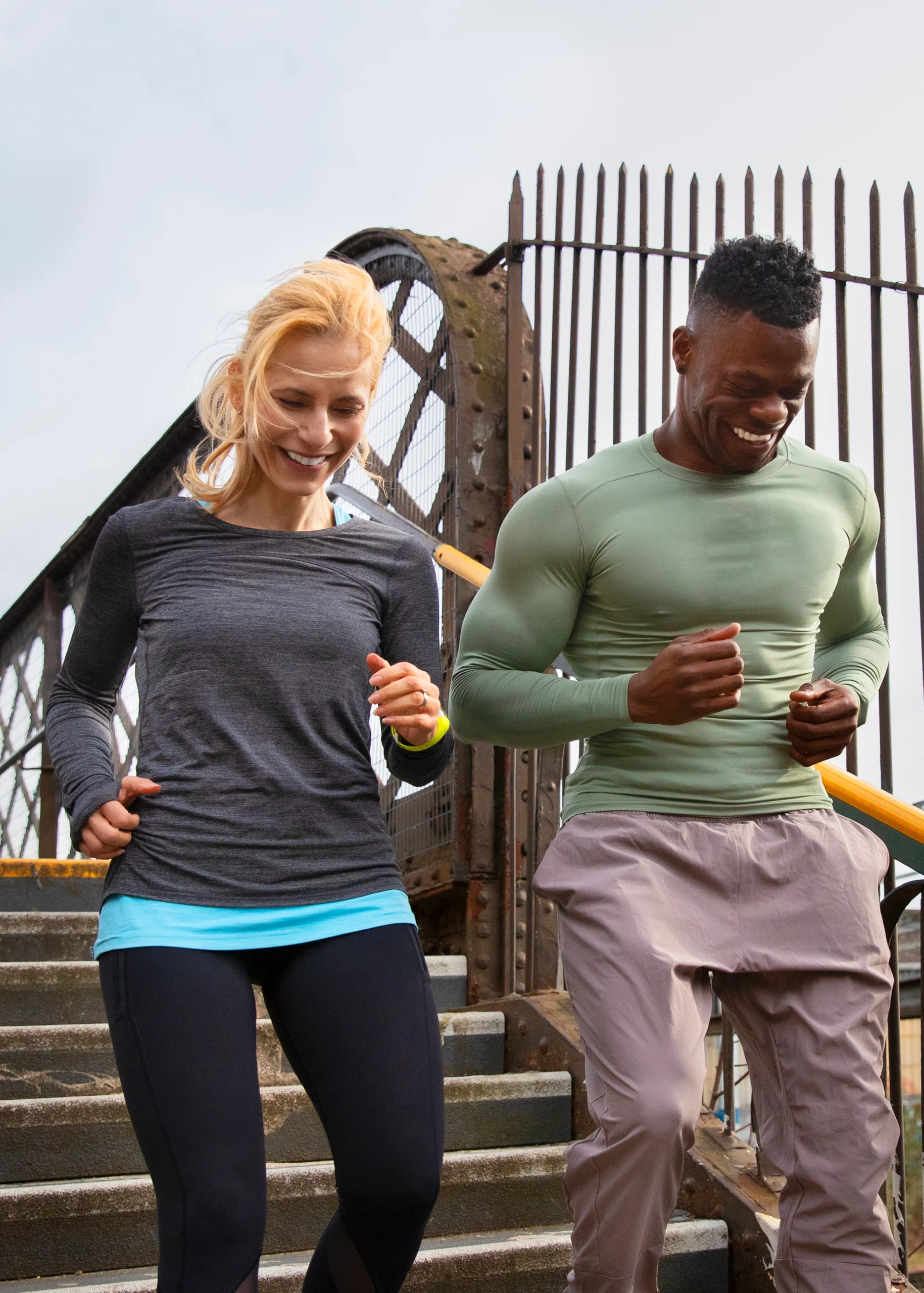 Two individuals jogging outdoors, smiling and enjoying an active lifestyle.