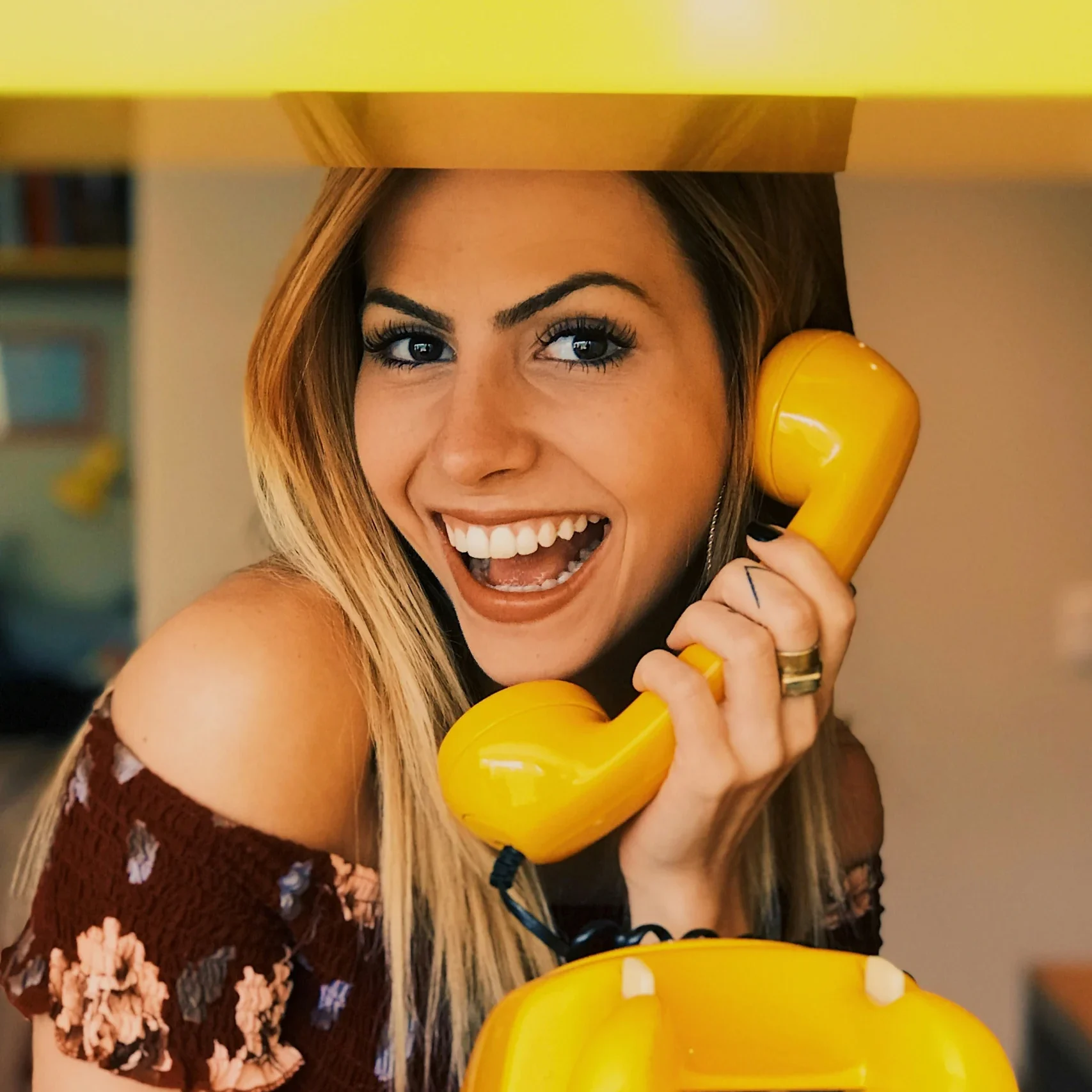 A woman answering the phone enthusiastically.